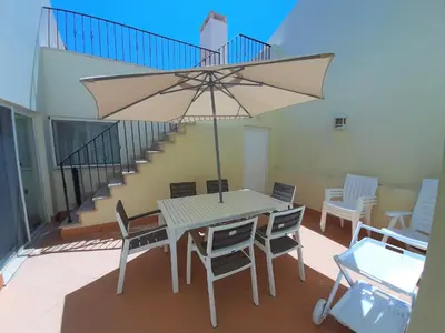 a table and chairs with an umbrella on a patio at Villa Bota by Garvetur in Almancil