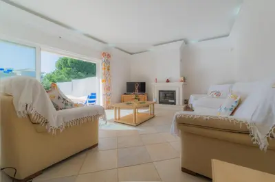 a living room with two chairs and a fireplace at Villa Bota by Garvetur in Almancil