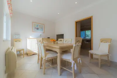 a dining room with a wooden table and chairs at Villa Bota by Garvetur in Almancil
