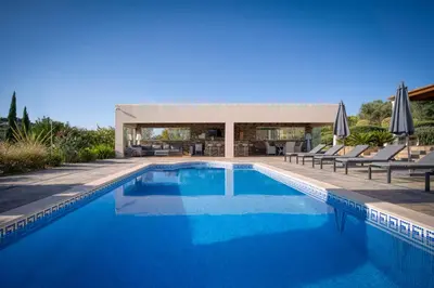 a row of chaises on a patio in front of a house at Casa Rosa - Heated Pool & Sea Views in Loulé