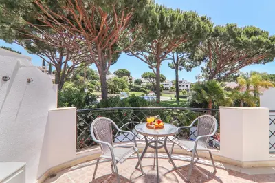 a patio with a table and chairs and an umbrella at Villa Karon in Almancil