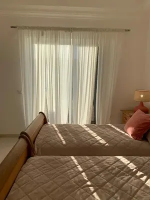 a bedroom with two beds with pink pillows on them at Villa Karon in Almancil
