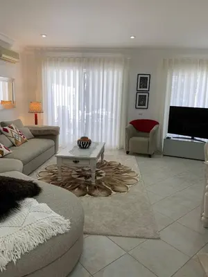 a living room with a television and a chair and a fireplace at Villa Karon in Almancil