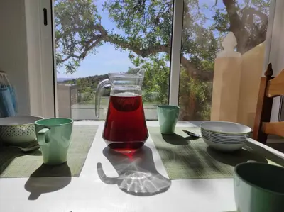 a table with a glass pitcher of red liquid on a table at Villa 3 Quartos, Piscina, AC, Vista Mar, Prestige For Home in Loulé