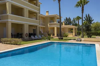 a villa with a swimming pool in front of a house at Real Alegria - Terrace with pool - Vilamoura in Vilamoura