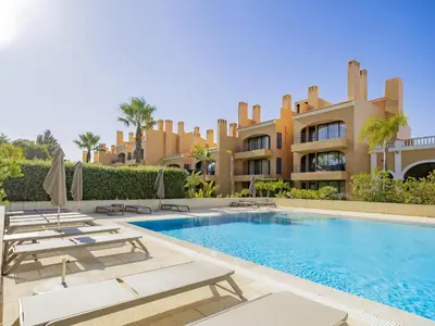 a villa with a swimming pool in front of a building at AL - Apartamento Vila Sol F5 P in Vilamoura