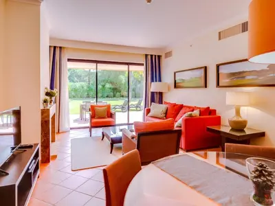 a living room with a red couch and chairs at AL - Apartamento Vila Sol F5 P in Vilamoura
