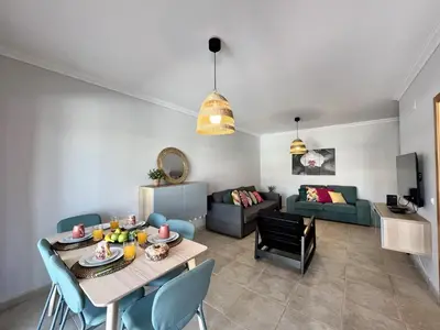 a living room with a table and a couch at Albufeira Garden Villa With Pool by Homing in Albufeira