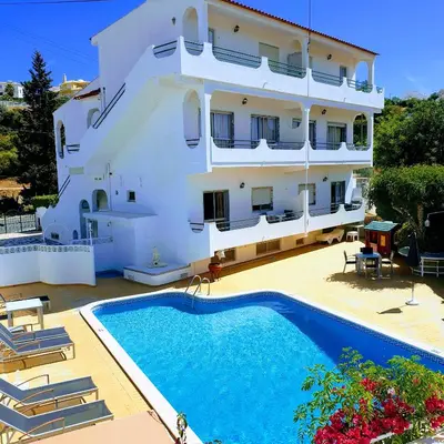 a building with a swimming pool in front of a building at AAA APARTAMENTS T0 Piscina Marina in Albufeira