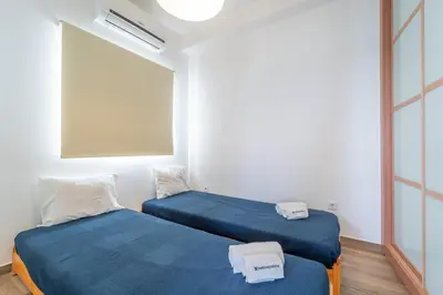two twin beds in a room with a window at Casa da Bateria by HelloVacations in Albufeira