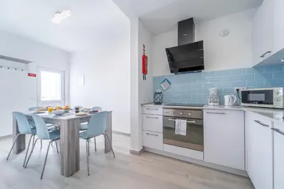 a kitchen with a table and chairs in a kitchen at Casa da Bateria by HelloVacations in Albufeira