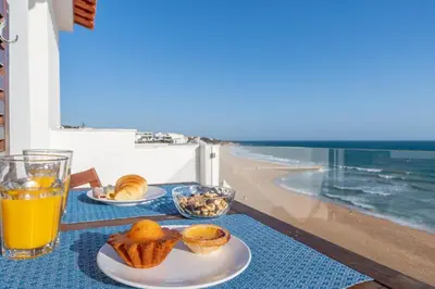 a table with two plates of food and a glass of orange juice at Casa da Bateria by HelloVacations in Albufeira