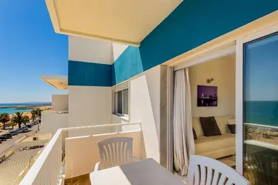 a balcony with a view of the beach and the ocean at Frente praia SIM T3 Praia Quarteira by HsRentals in Quarteira