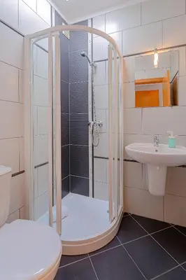 a bathroom with a shower and a toilet and a sink at Frente praia SIM T3 Praia Quarteira by HsRentals in Quarteira