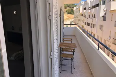 two chairs and a table on the balcony of a building at Le Modern' in Albufeira