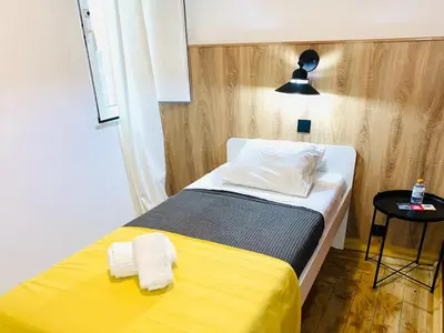 a small bedroom with a bed with a yellow blanket at GrowIN Digital Nomads in Faro