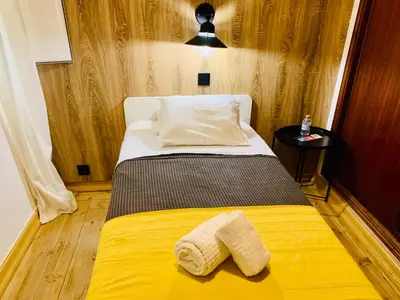 a bedroom with a yellow bed with two towels on it at GrowIN Digital Nomads in Faro