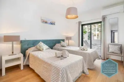 a room with two beds and a table with a lamp at Terrace Miguel Torga - Dream Lodging in Albufeira