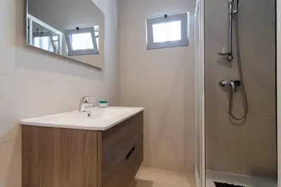 a bathroom with a sink and a shower with a mirror at De Hofnar Apartments Albufeira in Albufeira