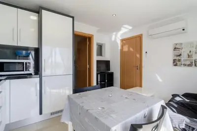 a white room with a table and a microwave at De Hofnar Apartments Albufeira in Albufeira