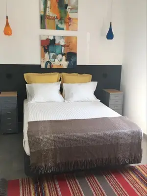 a bedroom with a large bed with two pillows at Casa dos Retratos Faro in Faro