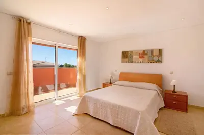 a bedroom with a bed and a large window at Casa Tulipas in Loulé