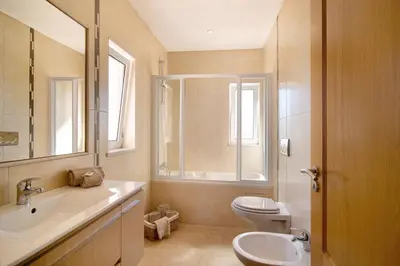 a bathroom with a sink and a toilet and a mirror at Casa Tulipas in Loulé