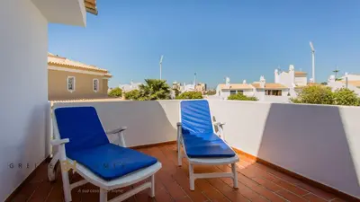 a pair of chairs sitting on a balcony at Greice Homes-650 meters from the beach, 4 bedrooms villa for holidays in Vilamoura-Quarteira in Quarteira
