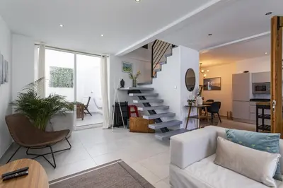 a living room with a white couch and a staircase at Casa Lobo - 2 bedrooms - Duplex in Faro
