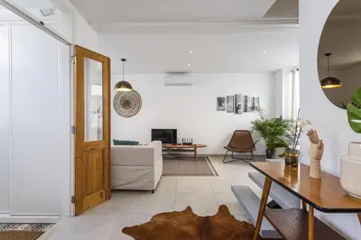 a living room with white walls and a wooden door at Casa Lobo - 2 bedrooms - Duplex in Faro
