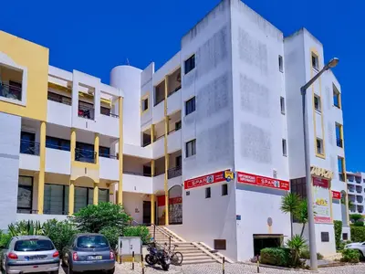 a white building with cars parked in front of it at FLH Vilamoura Balcony with Pool in Vilamoura