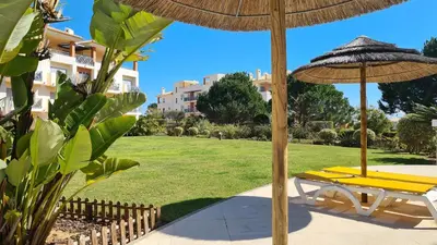 a patio with two umbrellas and a bench at 2 Terrace Town House in Albufeira