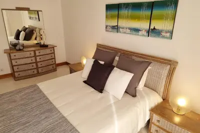 a bedroom with a bed with white sheets and pillows at Tivoli Apt8 with Pool&Garage in Vilamoura