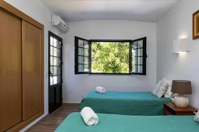 a bedroom with two green beds and a window at The Albufeira Concierge - Villa Balaia Sun Terrace in Albufeira