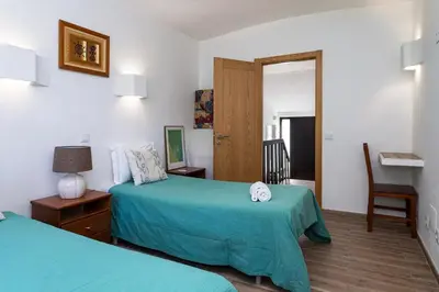 a hotel room with two beds and a doorway at The Albufeira Concierge - Villa Balaia Sun Terrace in Albufeira