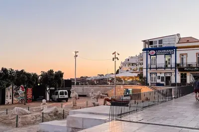a group of people walking on a city street at Old Fisherman's Corner 18 - Centro Old Town Albufeira in Albufeira
