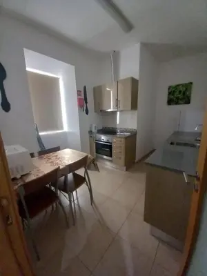 a kitchen with a wooden table and a tableasteryasteryasteryasteryasteryasteryastery at Sun Apartment on the Beach in Albufeira
