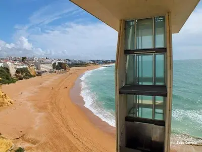 a building on the beach next to the ocean at Terrace apartament on the Sea in Albufeira