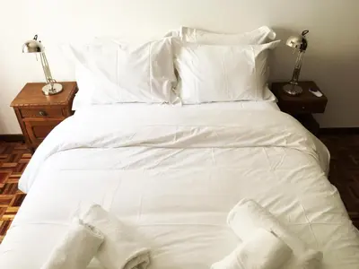 a bed with white sheets and white socks on it at Lemon Tree Apartments in Faro