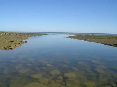 a large body of water with rocks in it at Lemon Tree Apartments in Faro