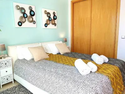 a bedroom with a large bed with white pillows at Beach Condo with Atlantic Ocean View by BeCherish in Olhos de Água