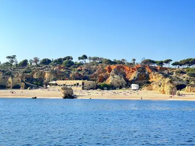 a beach with a group of people on the beach at Beach Condo with Atlantic Ocean View by BeCherish in Olhos de Água