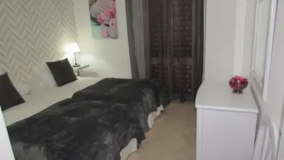 a bedroom with a bed with a black blanket at Apartamentos Julieta in Albufeira