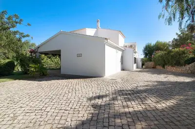 a backyard with a pool and a table and chairs at Casa da Alfarrobeira in Loulé