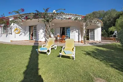 a group of chairs in front of a house at Casa do Barrocal in Almancil