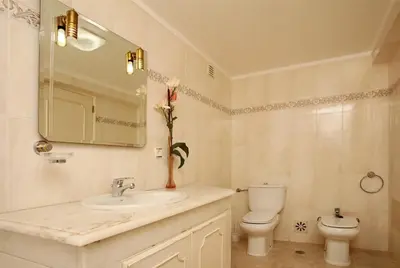 a bathroom with a sink and a toilet and a mirror at Villa Jumar in Albufeira