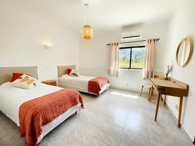a bedroom with two beds and a desk and a window at Vila Castelo in Vale do Lobo