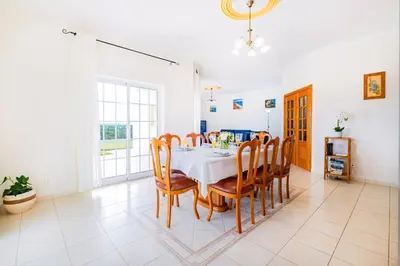 a dining room with a white table and chairs at Filomena Golf Paradise in Guia
