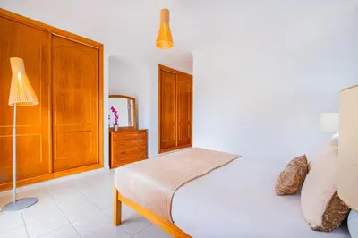 a bedroom with a bed and a dresser and a lamp at Filomena Golf Paradise in Guia