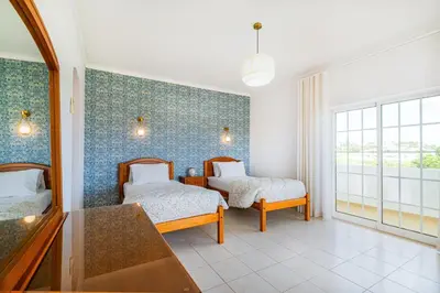 a bedroom with two beds and a mirror at Filomena Golf Paradise in Guia